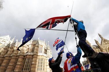 Pro-Europe demonstrators hang British and EU flags during a protest outside parliament. AP.