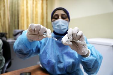 A Palestinian medical worker prepares a dose of the Pfizer-BioNTech vaccine at the Palestinian Medical Centre in the West Bank. EPA