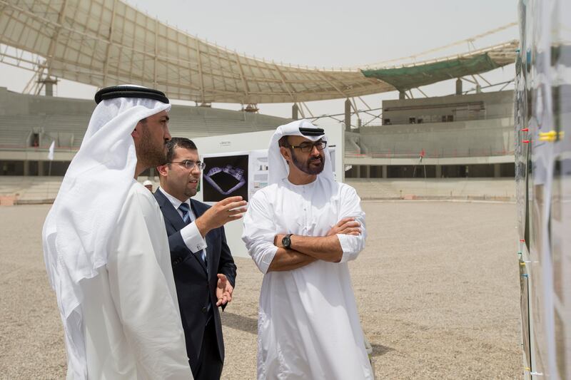 AL AIN, EASTERN REGION OF ABU DHABI, UNITED ARAB EMIRATES - May 08, 2013: HH General Sheikh Mohamed bin Zayed Al Nahyan Crown Prince of Abu Dhabi Deputy Supreme Commander of the UAE Armed Forces (R), looks at illustrations of the Hazza Bin Zayed Stadium, which will serve as the new home ground of Al Ain Football Club. Seen with HE Mohamed Mubarak Al Mazrouei Under-Secretary of the Crown Prince Court of Abu Dhabi (L), and Kareem Nagy Hassan CEO of Al Qattara Investments (2nd L)..( Ryan Carter / Crown Prince Court - Abu Dhabi ).---