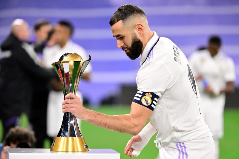 Real Madrid's French forward Karim Benzema grabs the  Club World Cup trophy before the start of the match. AFP