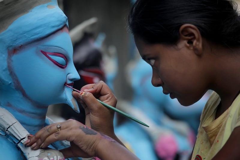 An Indian clay artist, Sujata Chitrakar, works with an idol of the goddess Kali ahead of Diwali in Kolkata. EPA