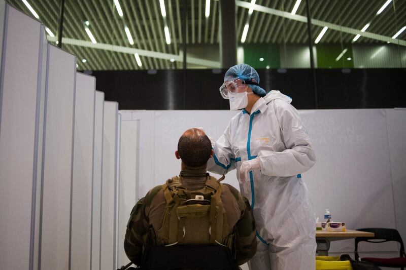 A health worker administers a Covid-19 swab test on a French soldier at Charles de Gaulle airport, France. Bloomberg