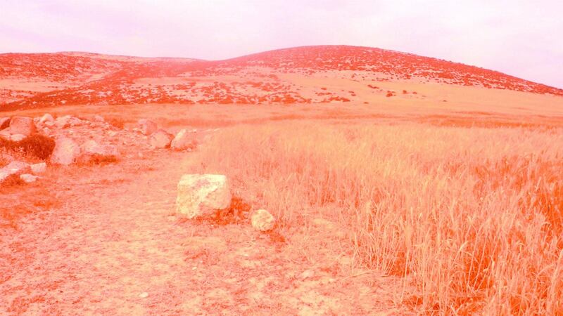 Photograph through red film of an area in the West Bank, Palestine, where nuclear waste is reported to be buried. From a new artist's publication by Inas Halabi, Lions Warn Us of Futures Present, 2017
