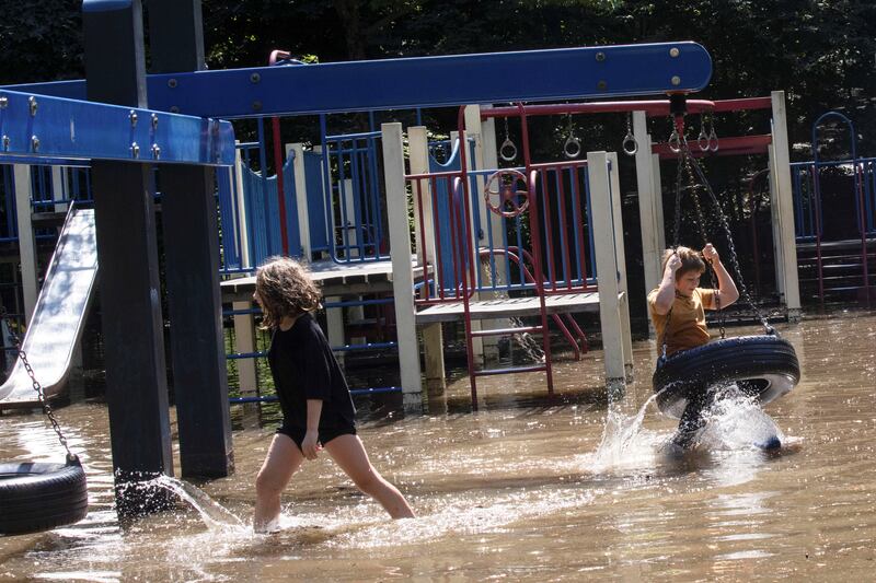 Tiger Lily Koch, 10, plays with her brother, Adrien Koch at a flooded playground after the remnants of Tropical Storm Ida brought drenching rain and the threat of flash floods and tornadoes to parts of the northern mid-Atlantic, in the Brooklyn borough of New York City, on September 2, 2021.  Reuters
