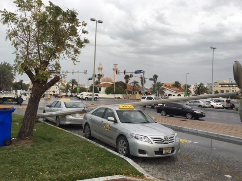 A lamppost crushes a taxi at the junction of Hazza bin Zayed Street and Mubarak bin Mohammed Street near the Shaheen Supermarket and Khalidiya Police Station. Ramona Ruiz / The National