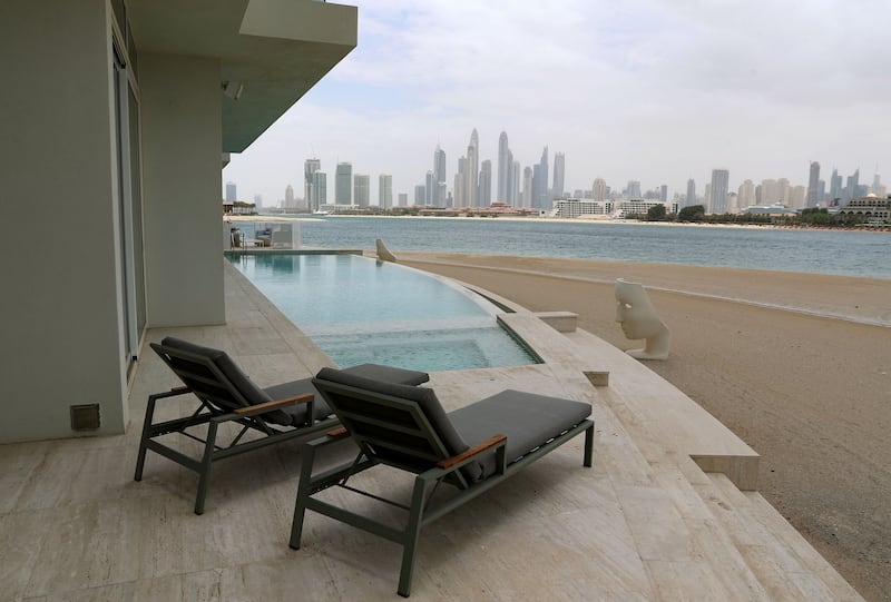 A Palm Jumeirah property with an infinity pool along the beach. The property is on the market with LuxuryProperty.com