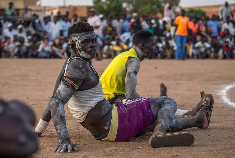 Wrestlers sit by the ring during a traditional Nuba wrestling competition in Sudan's capital Khartoum.