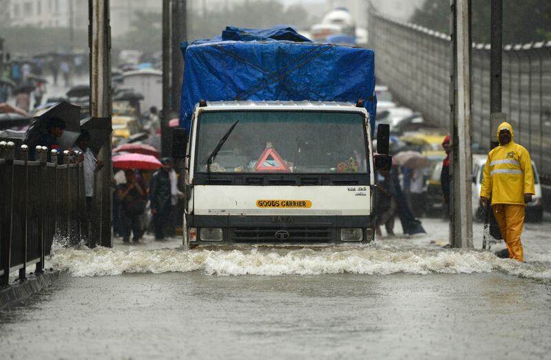 Vehicles drive through a flooded street during heavy rain showers in Mumbai on August 29, 2017. Heavy rain brought India's financial capital Mumbai to a virtual standstill on August 29, flooding streets, causing transport chaos and prompting warnings to stay indoors. Dozens of flights and local train services were cancelled as rains lashed the coastal city of nearly 20 million people. Punit Paranjpe / AFP