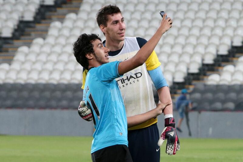 A fan that ran on to the pitch takes a selfie with goalkeeper Costel Pantilimon. Christopher Pike / The National