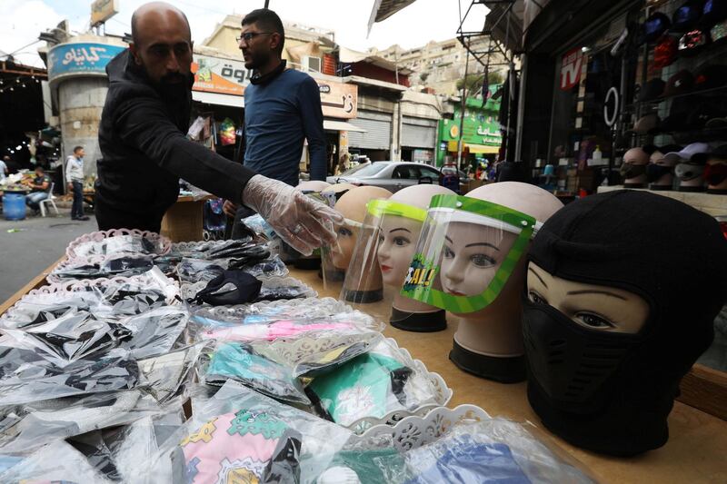 A seller displays face masks and face shields for customers in front of his shop in downtown Amman, Jordan. Reuters