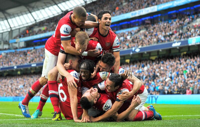 Arsenal’s Laurent Koscielny is mobbed by teammates as he celebrates scoring against Manchester City. 23/09/2012. Martin Rickett / FPA / LDY Agency