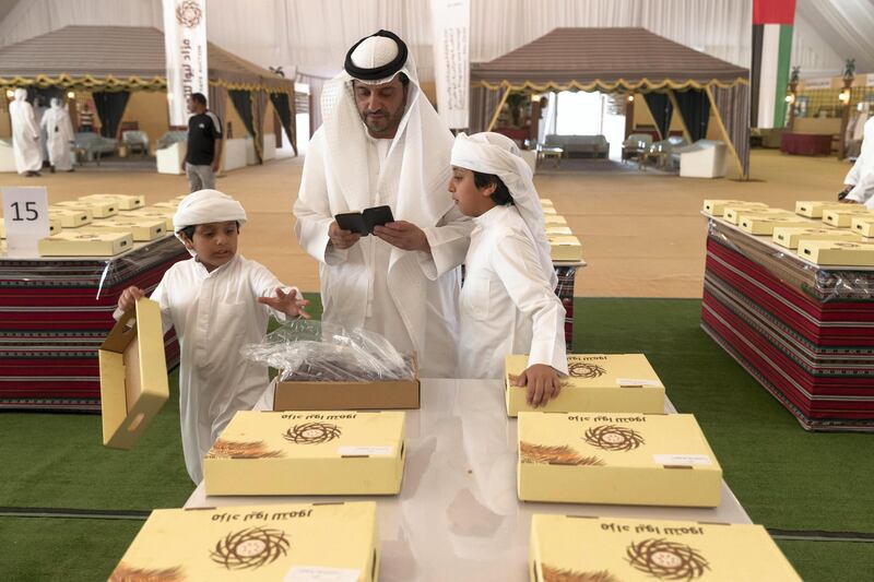 LIWA, UNITED ARAB EMIRATES. 05 October 2017. Liwa Date Auction. Opening day of the first annual Liwa Date Auction. Zayed Mohammed Khalifa inspects some dates along with his sons before the auction. (Photo: Antonie Robertson/The National) Journalist: Anna Zacharias. Section: National.