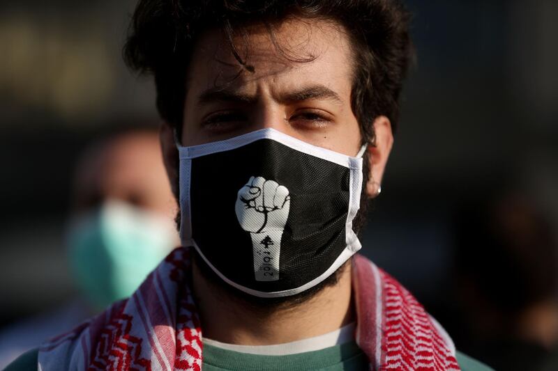 A Lebanese protester, wearing a protective mask bearing a fist, is pictured during a demonstration in the capital Beirut on April 28, 2020. AFP