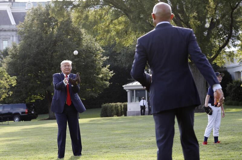 U. President Donald Trump catches a baseball thrown by Mariano Rivera, former pitcher for the New York Yankees. Bloomberg