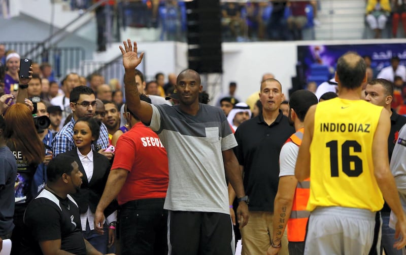 LA Lakers NBA player Kobe Bryant salutes the crowds as he arrives to American University of Dubai basketball court to coach a team made up of local celebrities on  September, 27, 2013.  Bryant arrived for a Health and Fitness Weekend, to promote awareness of diabetes in the United Arab Emirates in his first trip to a Middle East country. AFP PHOTO/MARWAN NAAMANI (Photo by MARWAN NAAMANI / AFP)