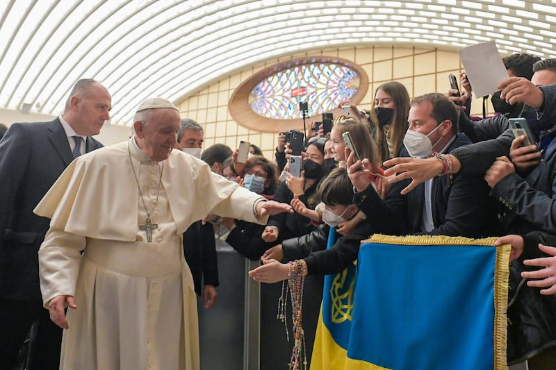 Pope Francis meets visitors holding the Ukrainian flag during his weekly general audience in the Vatican. AFP