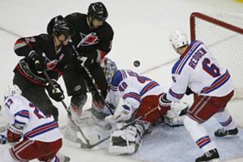 The New York Rangers Chris Drury, left, Steve Valiquette, second right, and Wade Redden, right, stop the Carolina Hurricanes players Eric Staal, second left, and Tuomo Ruutu, centre, during a goalmouth scramble on Monday. Carolina went on to win the game 3-0.