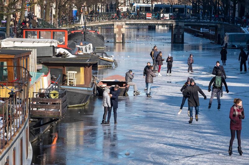 People skated and walked on a small stretch of ice between two bridges close to the landmark Westerkerk in Amsterdam, Netherlands before growing cracks in the surface forced all but the most daring off the ice. AP