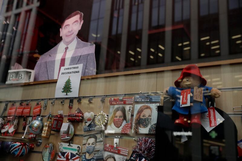 Face masks, including a Christmas themed one, are displayed in the front window of a shop in central London. AP Photo