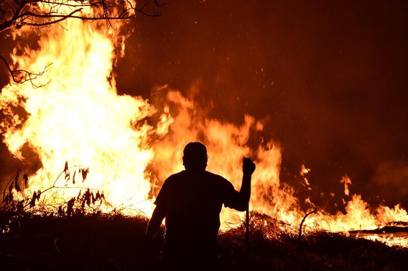 A man is seen in front of a forest fire in El Hatillo, Francisco Morazan department, Honduras. AFP