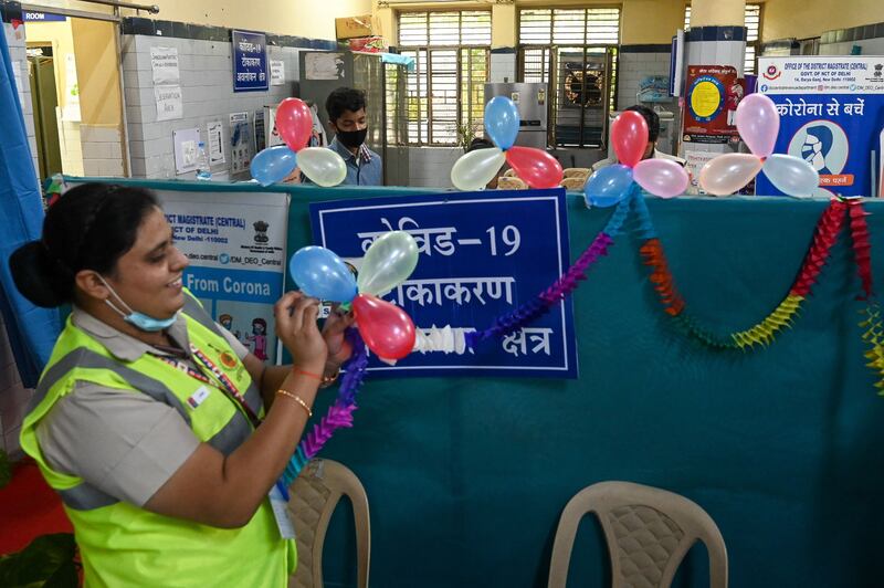 Volunteers decorate a vaccination centre to celebrate India administering its billionth Covid-19 vaccine. Prakash Singh / AFP
