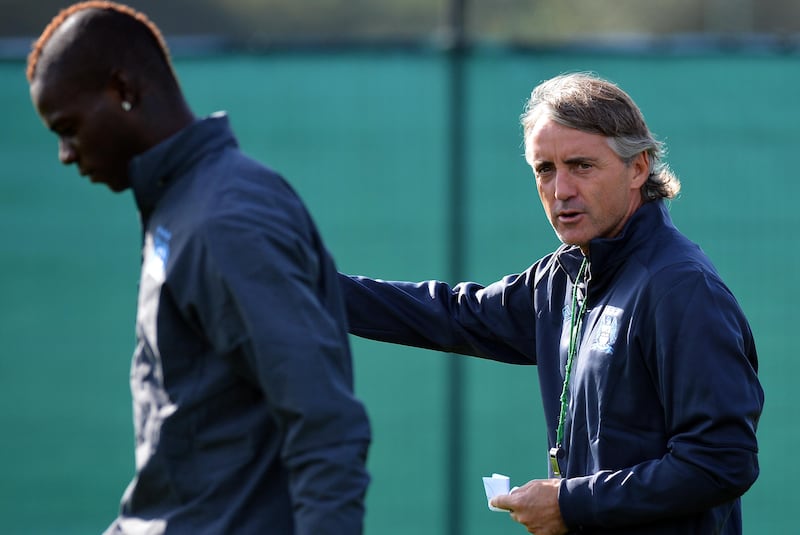 Manchester City's Italian manager Roberto Mancini (R) arrives with Manchester City's Italian forward Mario Balotelli (L) for a training session in Manchester, north-west England, on September 17, 2012 ahead of their UEFA Champions League Group D football match against Real Madrid on September 18. AFP PHOTO/PAUL ELLIS