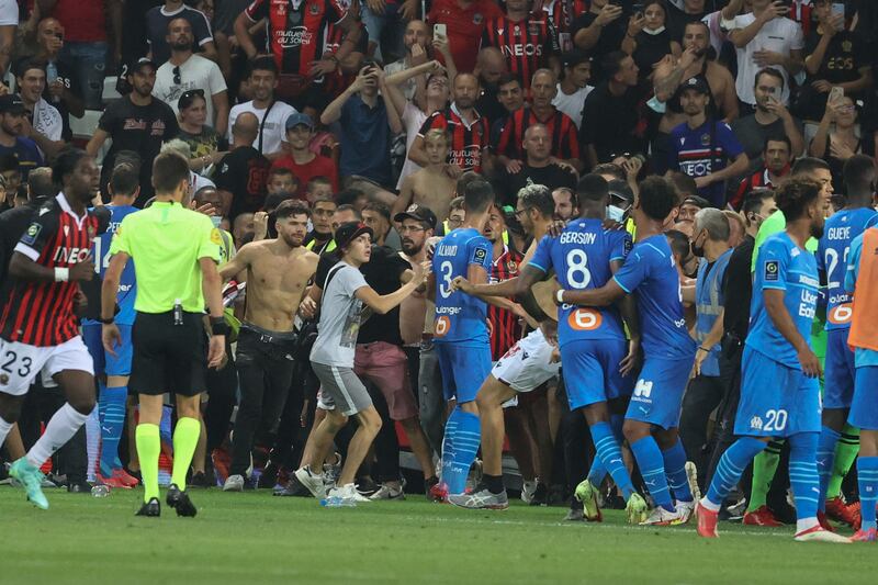 Fans invade the pitch. AFP