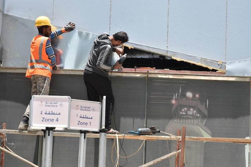 Workers fixing the damage at Abha airport. AFP