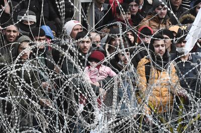 Migrants, as seen from the Greek side of the Greece-Turkey border near Kastanies, wait on the Turkish side, on March 02, 2020. AFP