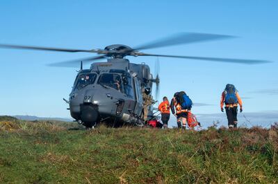 In this photo provided by the New Zealand Defence Force, a helicopter waits as search and rescue workers board during a rescue operation to find two missing trampers in the Kahurangi National Park in the South Island of New Zealand, Wednesday, May 27, 2020. Two hikers rescued in the New Zealand wilderness Wednesday got lost in fog and exhausted their food but survived 19 days with only minor injuries, police said. (CPL Naomi James/New Zealand Defence Force via AP)