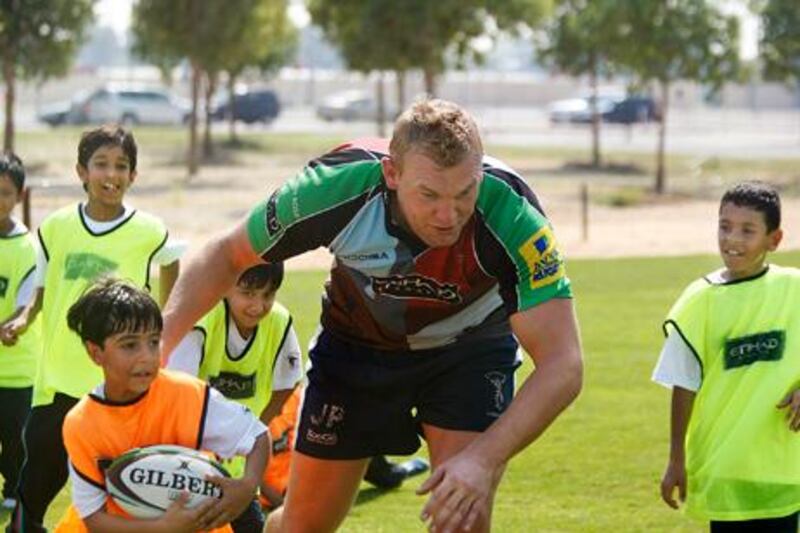 James Percival, London Harlequins lock, puts schoolchildren from the Emirates National School through their paces yesterday during a coaching session at Zayed Sports City.