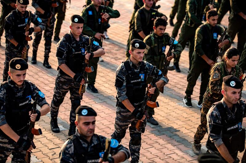 Members of the Kurdish Internal Security Police Force of Asayish attend the funeral of a fellow police officer, who was killed in a car bomb attack claimed by the Islamic State group (IS) earlier in the week, in northeastern Syrian Kurdish-majority city of Qamishli on August 20, 2019.  / AFP / Delil SOULEIMAN
