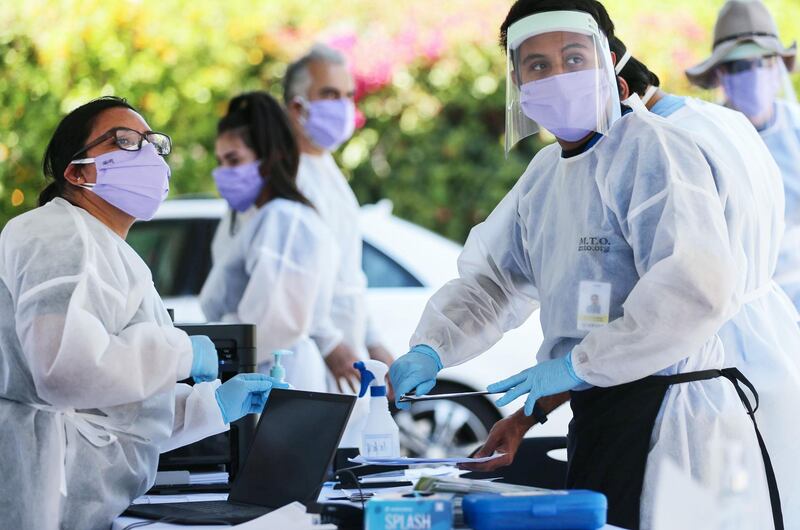 Healthcare workers facilitate tests at a drive-in Covid-19 testing centre at MTO Shahmaghsoudi School of Islamic Sufism in Los Angeles, California, US. AFP