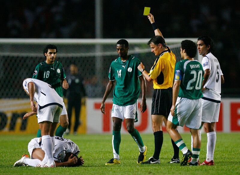 Saudi Arabia's Saud Khariri, centre, is shown a yellow card by match referee Mark Shield of Australia during the 2007 Asian Cup final against Iraq. Reuters