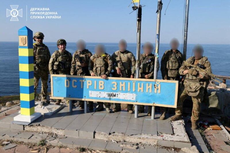 Ukrainian border guards stand next to a border sign on Snake Island in the Black Sea, in August. Reuters