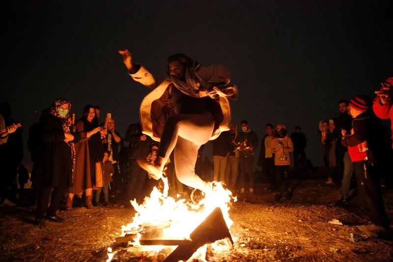 The girl leaps over the flames, during Charshanbeh Suri celebrations in Tehran. Jumping over the fire is considered a purification practice and is accompanied by a song. EPA