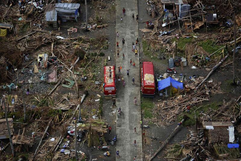 Survivors of Typhoon Haiyan wave as a U.S. military helicopter delivering aid flies over their isolated village north of Tacloban. Mobbed by hungry villagers, U.S. military helicopters dropped desperately needed aid into remote areas of the typhoon-ravaged central Philippines, as survivors of the disaster flocked to ruined churches on Sunday to pray for their uncertain future.  Damir Sagolj/Reuters