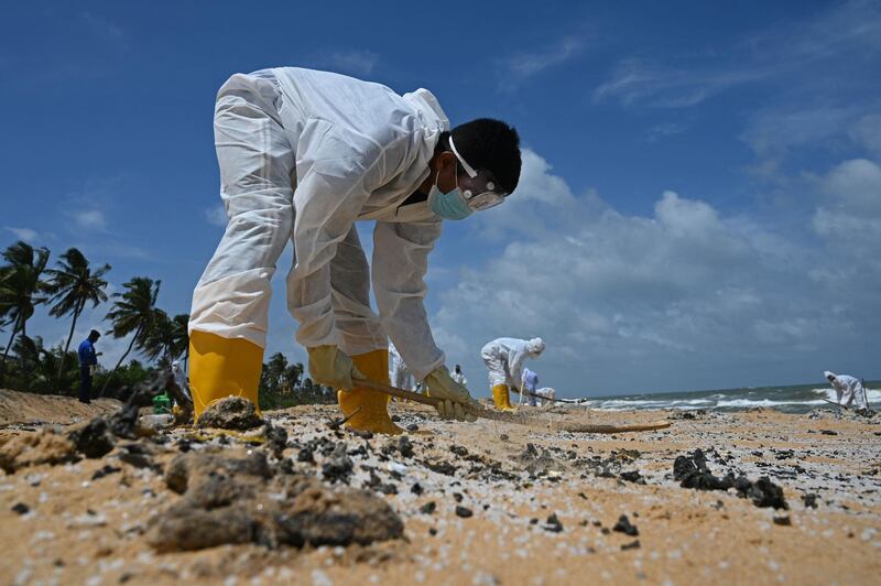 Members of Sri Lankan Navy remove debris washed ashore. AFP