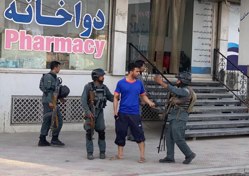 Afghan security forces stop a man near the site of an attack in Kabul AP