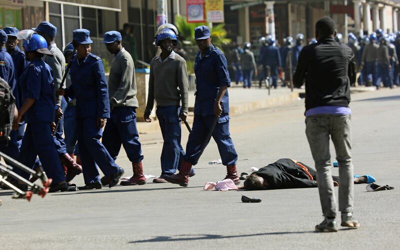 A woman lies in the road after being injured by police. AP Photo