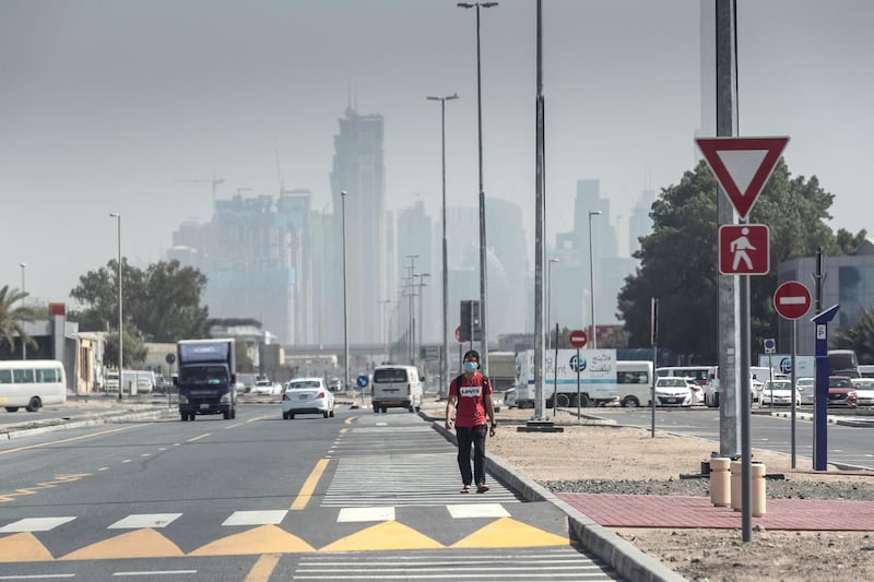 DUBAI, UNITED ARAB EMIRATES. 01 APRIL 2020. A man walks, while wearing a mask, to get to work during the ongoing Stay At Home policy being enforced on a National level in the UAE. With generally mild weather and the general slow down in the use of public transport many commuters are opting to walk distances they would previously have used motorised transport for. (Photo: Antonie Robertson/The National) Journalist: Standalone. Section: National.. 