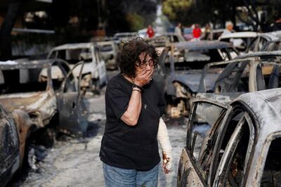 A woman reacts as she tries to find her dog, following a wildfire at the village of Mati, near Athens, Greece July 24, 2018. REUTERS/Costas Baltas      TPX IMAGES OF THE DAY