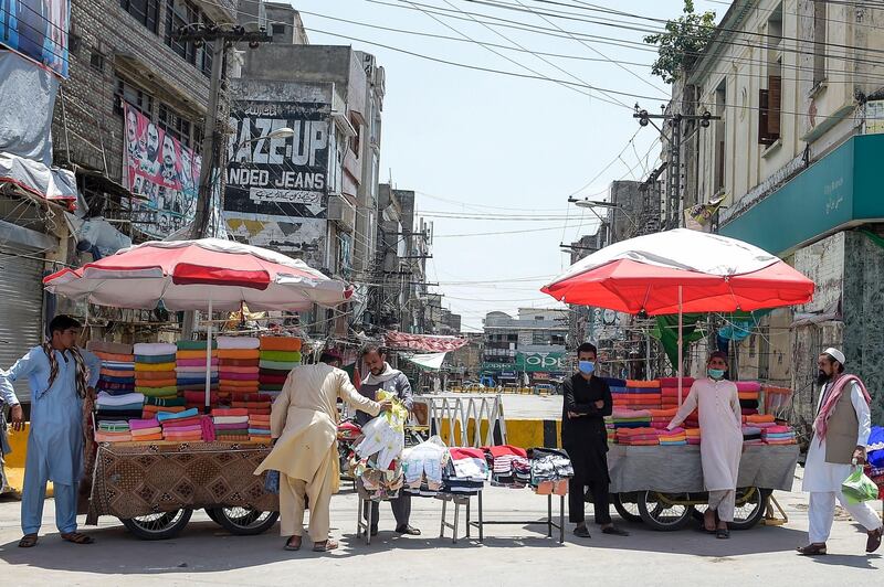 Vendors standing near their stalls wait for customers in front of a market sealed by authorities as a preventive measure against the coronavirus in Rawalpindi.  AFP
