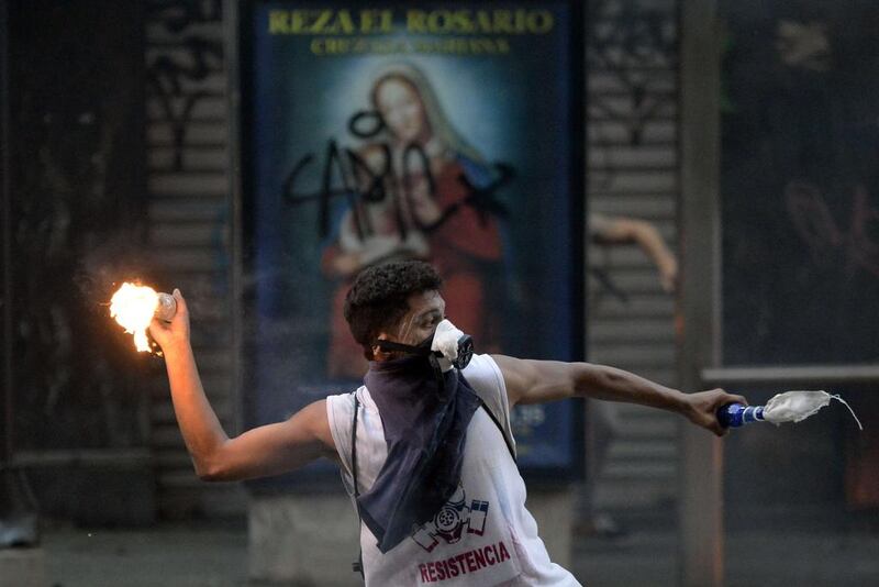 A demonstrator clashes with members of the national guard during a protest against Venezuelan President Nicolas Maduro in Caracas. Juan Barreto / AFP 