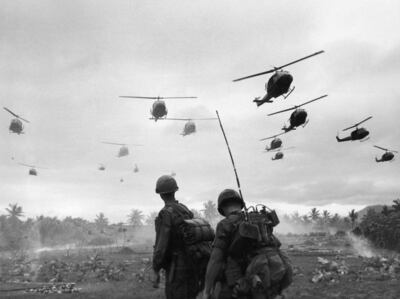 The second wave of combat helicopters of the 1st Air Cavalry Division fly over an RTO and his commander on an isolated landing zone during Operation Pershing, a search and destroy mission on the Bong Son Plain and An Lao Valley of South Vietnam, during the Vietnam War. The two American soldiers are waiting for the second wave to come in.  Getty
