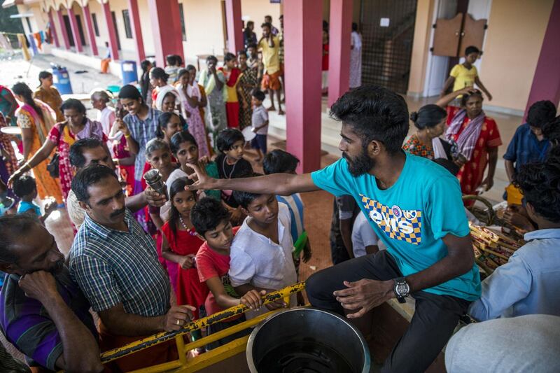 Volunteers serve tea and snacks to flood victims at a relief camp set up at Sree Narayana College Cherthala, affiliated to the University of Kerala, in Alappuzha, Kerala, India, on Thursday, Aug. 23, 2018. India's tourist hub of Kerala is shifting its focus to relief and rehabilitation work to assist millions of people affected by the worst flood in a century as rescue operations wind down. Photographer: Prashanth Vishwanathan/Bloomberg