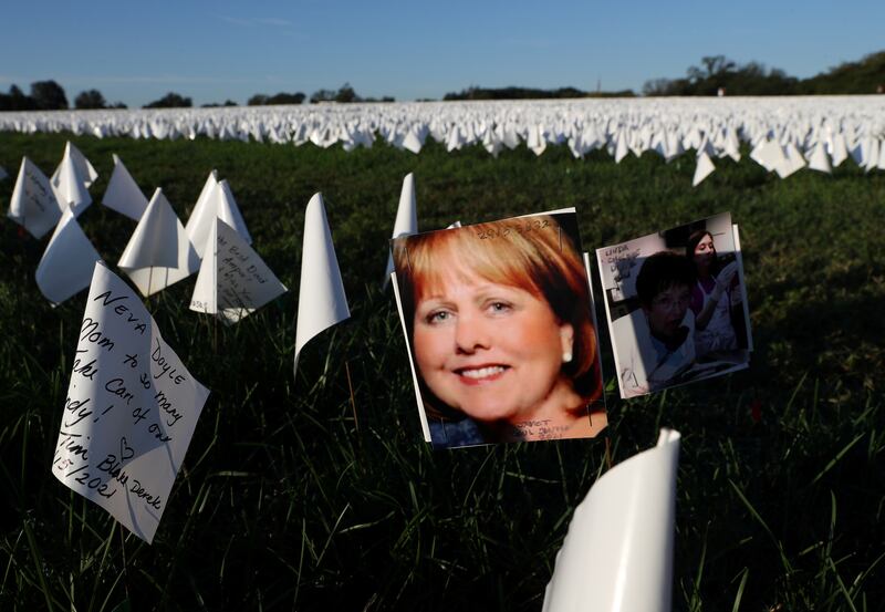 A photograph can be seen attached to a flag as part of Suzanne Brennan Firstenberg's "In America: Remember", a memorial for Americans who died due to the coronavirus disease (COVID-19) as the national death toll nears 700,000, next to the Washington Monument in Washington, U. S. , October 1, 2021.  REUTERS/Leah Millis REFILE - CORRECTING FULL NAME.  NO RESALES.  NO ARCHIVES