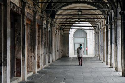 A man wears a protective mask in a virtually deserted Venice as the Italian government continues restrictive movement measures to combat the coronavirus outbreak, in Venice, Italy, March 14, 2020. REUTERS/Manuel Silvestri