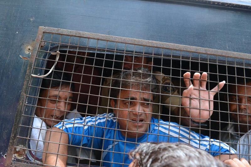 Unidentified convicted Indian men look out from a police vehicle after a verdict in the 2002 Gujarat riot massacre in Ahmedabad on June 2, 2016. A special Indian court convicted two dozen Hindus on June 2 over a massacre during religious riots 14 years ago when prime minister Narendra Modi was chief minister of Gujarat state. Sam Panthaky/AFP

