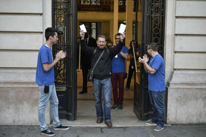 The first French customer to buy the latest iPhone holds two boxes containing the iPhone6, as he exits the Apple Store in Paris. Fred Dufour / AFP Photo